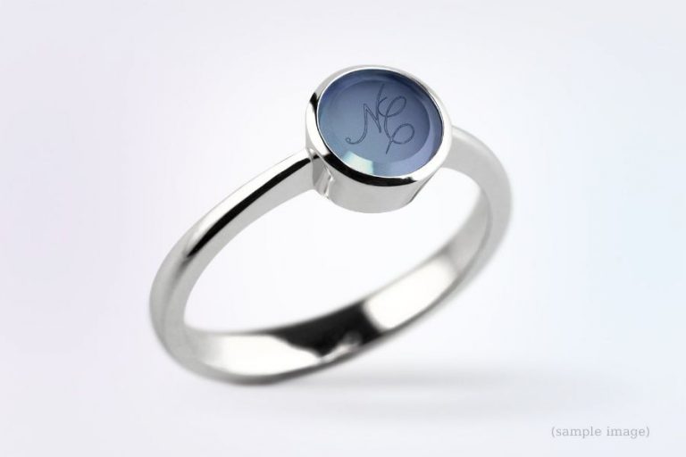 silberner ring mit blauem edelstein, mit einer gravur, die initialen zeigt